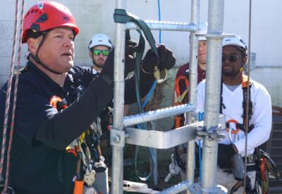 An instructor demonstrates climbing safety procedures for Nunez Wind Energy Technology students.