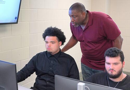 Martin Davis, Nunez Cybersecurity Chair, assists a student in class.