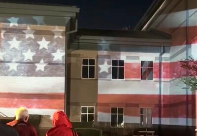 Guests observe a patriotic light show outside the Nunez Auditorium following Honoring Our Veterans, a special Veterans Day edition of Nunez’s History Lecture Series.