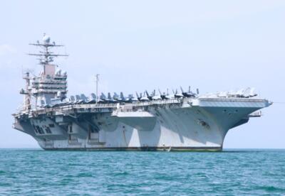 A U.S. Navy aircraft carrier is shown in open water.