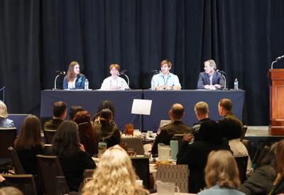Nunez students are seated at a table on stage for a panel discussion.