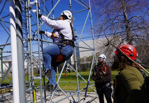 Nunez Wind Energy Technology students practice climbing safety on a metal ladder.