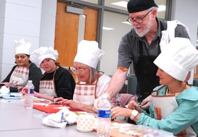 Chef Doyle DeForest, Nunez Culinary Instructor, assists participants during a carrot cake leisure course in April 2026.