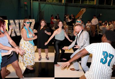 Guests are shown dancing during the 2025 Summer Baseball Bash.