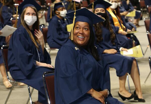 Girl smiling wearing graduation cap and robe