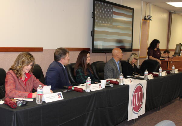 Legislators sitting at a head table during the forum