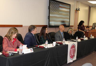 Legislators sitting at a head table during the forum