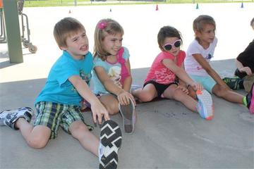 Boys and girls sitting on the ground stretching