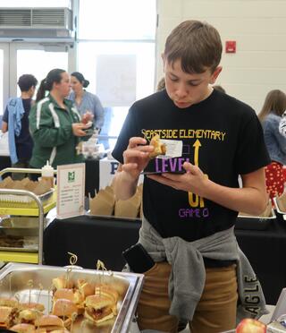 Student tasting a burger