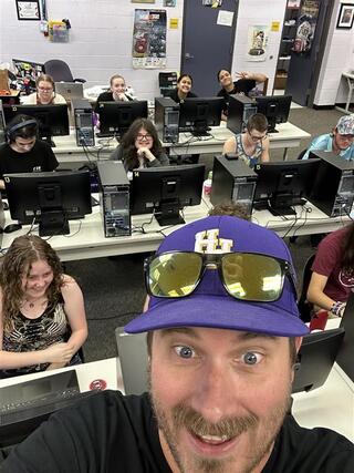 Selfie of teacher and students at their computer stations