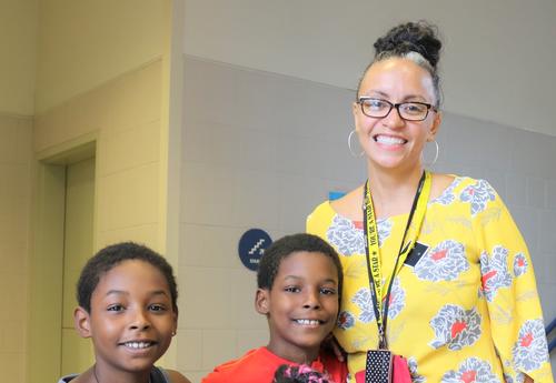 Principal Gayle poses with three students on the first day of school.