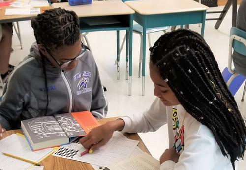 Two students work on English language arts project