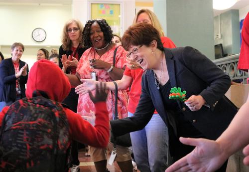 Mayor Kathy Sheehan high fives an ǷԴ School of Humanities student as he walks in to class.