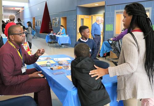 Sheridan Prep staff member discusses district's attendance policy with a mom and her students.