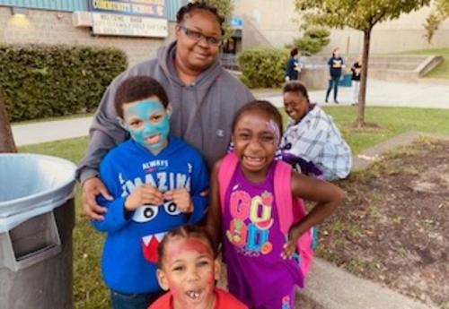 Am Arbor Hill Elementary parent and her three children pose outside the school during Family Field Day.