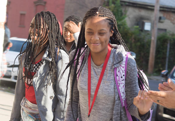 Smiling student walks into school during clap-in.