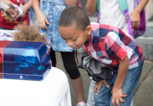 Boy talks to Otto the Auto, a robotic police car.