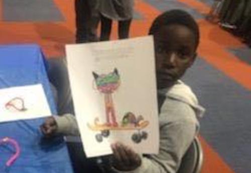 An Albany School of Humanities students holds up his work during the school's Literacy Night.