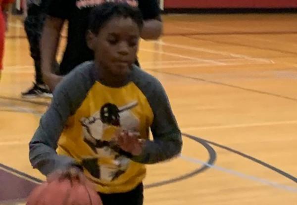 A sixth-grader practices driblling with the Albany Patroons basketball team.