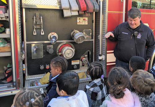 A member of the Albany Fire Departments teaches students about the fire truck.