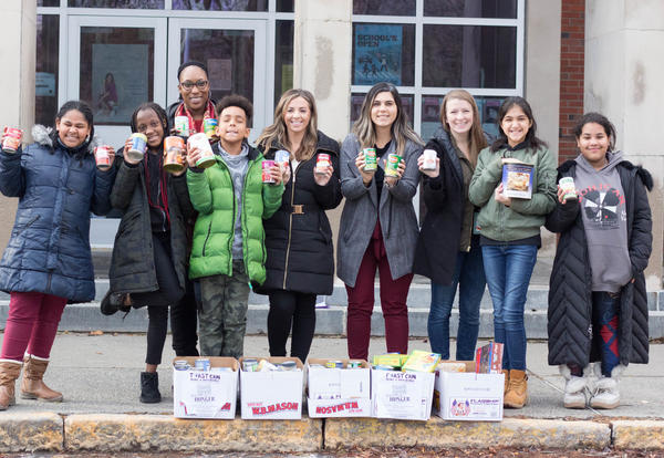 Students and teachers stand by boxes of food they collected to donate to a local food pantry