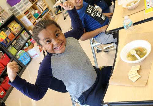 A second grade boy enjoys a bowl of Stone Soup, made by the class.