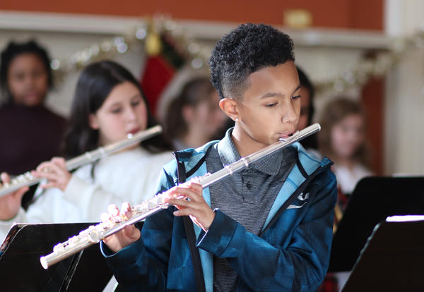 Student playing the flute during the performance at Academy Park.