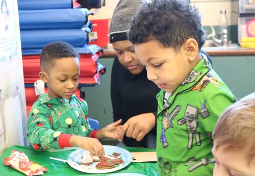 Prekindergarten students decorate cookies.