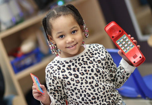 Pre-K girl operates a play telephone