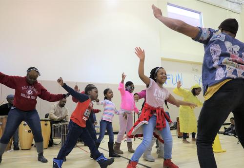 Students learn how to dance during an assembly.