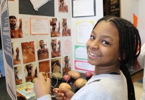 A Sheridan Prep student poses with her science fair project.