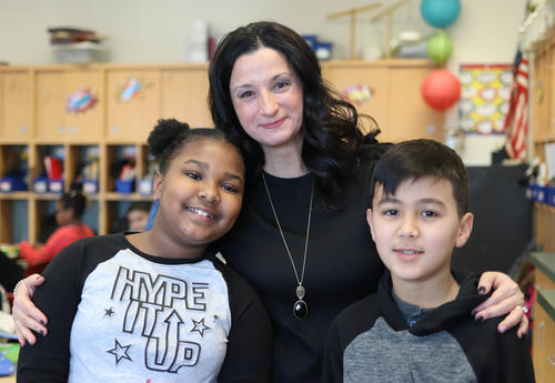 Caryn Dwyer posing for a photo with two students.