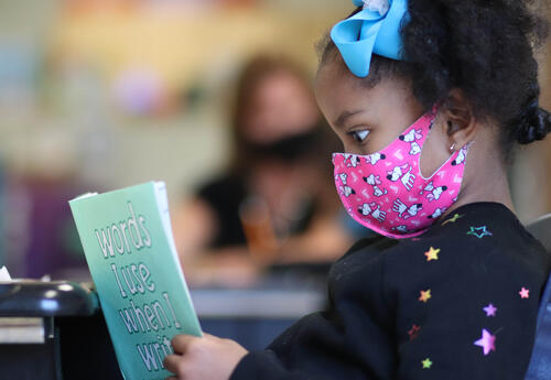 Student reading a booklet titled "Words I use when I write."