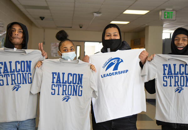 Three boys and a girl pose with Falcon t-shirts