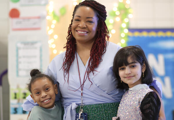 Juaneika Agyeman posing for a photo with two students