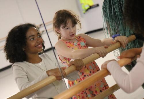 Two students do a barre work out during the summer arts program dance class.