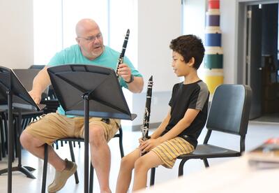 Teacher Mark Sudano coaching a student on how to play the clarinet