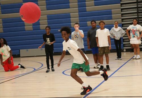 Students play kickball with PE teachers during a summer program at Albany High School
