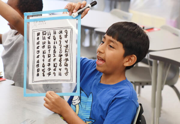 Student shows off their numbers chart