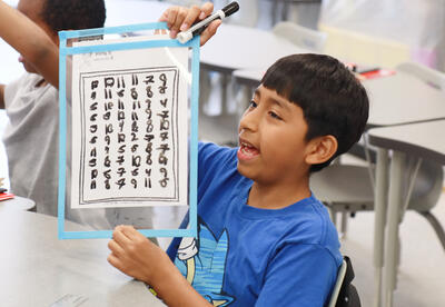Student shows off their numbers chart
