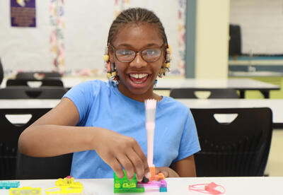 Student uses circuit she built to power a light