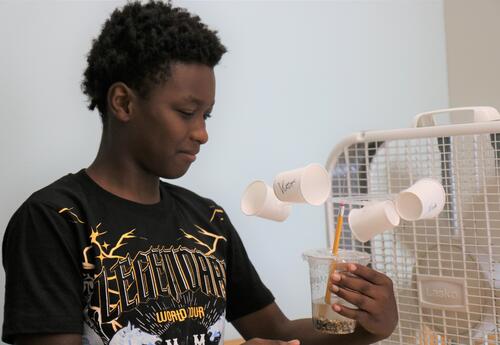 A students tests his anemometer with a fan.