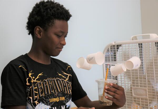 A students tests his anemometer with a fan.