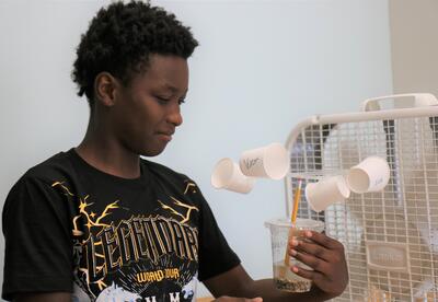 A students tests his anemometer with a fan.