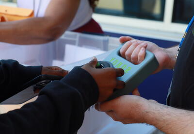 Student unlocking a cell phone pouch at school