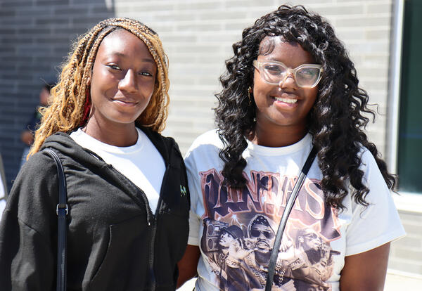 Photo of two Albany High students in front of the school building