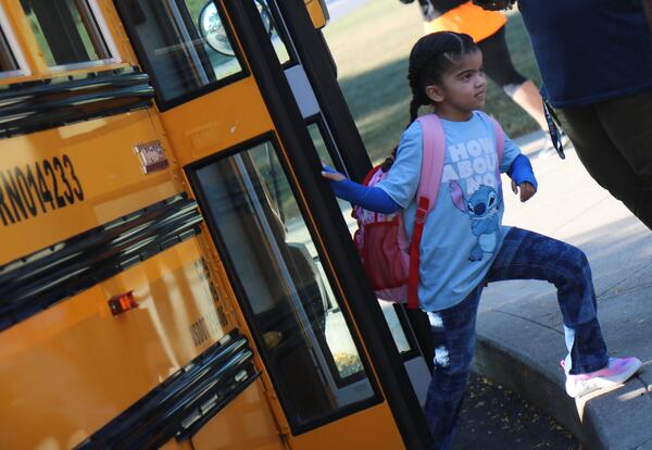 A students hops off the bus on the first day of school.