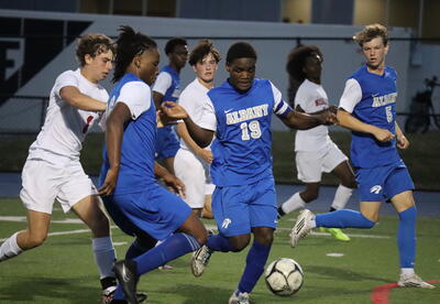 Photo of Albany High player Amisi Juma controlling the soccer ball on the field