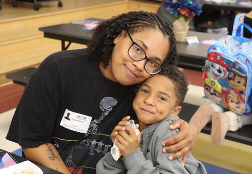 Student is hugged by their special breakfast guest