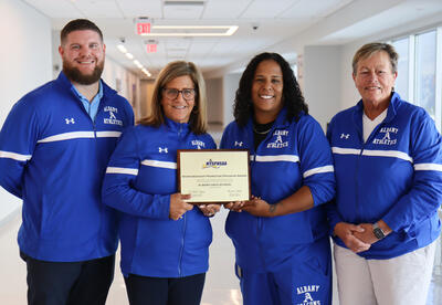 Glenn Westfall Jr., Kimberly Pilla, Rachel Swann and Mary Anne Fritz holding award plaque
